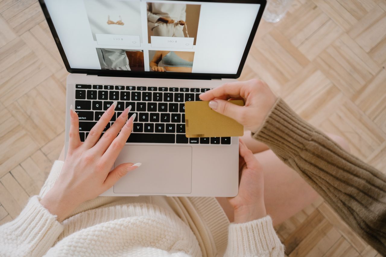 creative-03 Person shopping online using a laptop and credit card, highlighting e-commerce convenience.